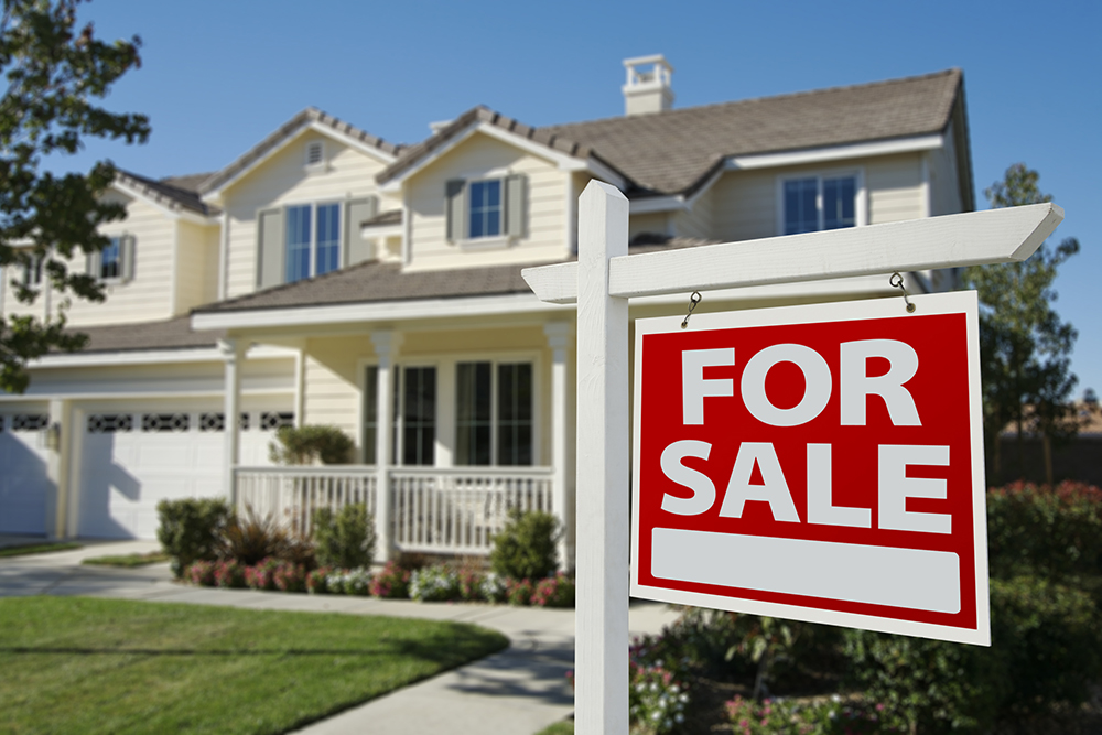 For sale sign In front of a residential real estate property before receiving home inspection services